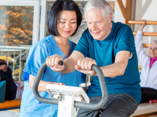 Caregiver helping senior man exercise