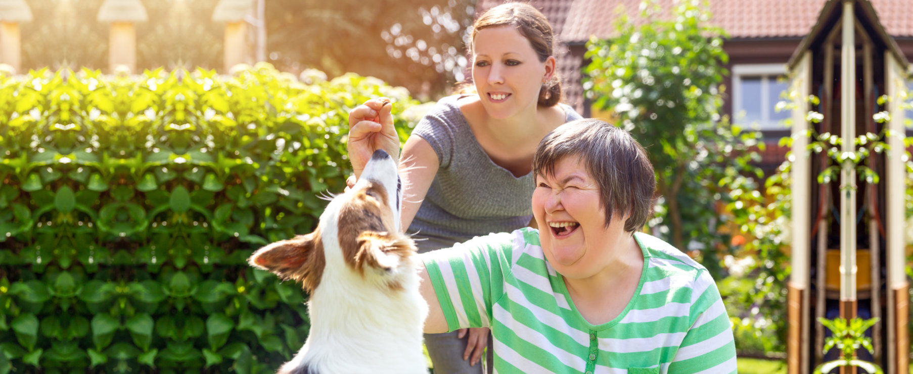 Caregiver and a woman playing with the dog